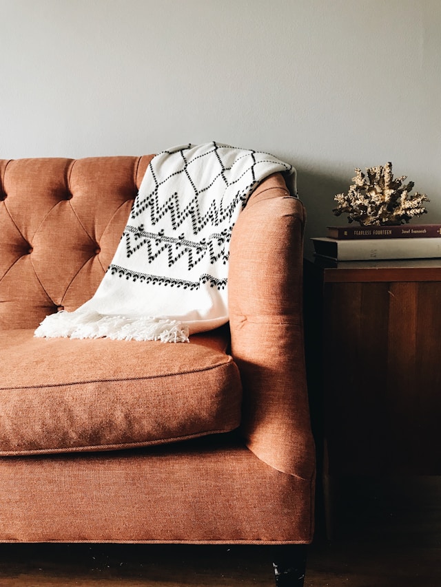 orange sofa with white throw blanket