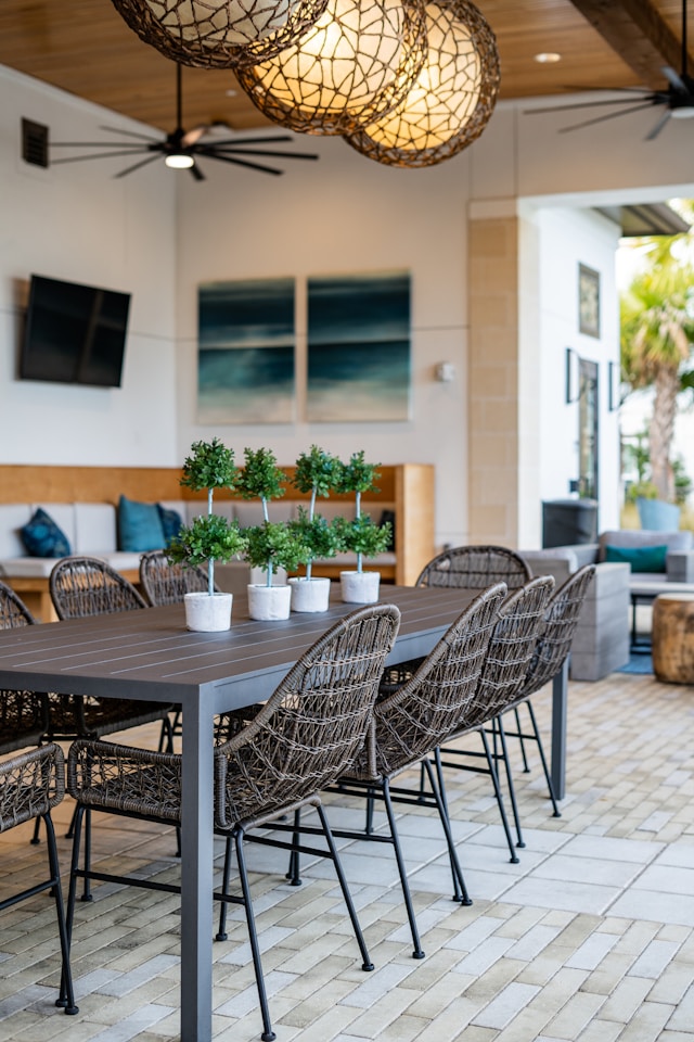 an outdoor wicker dining set with plants on table