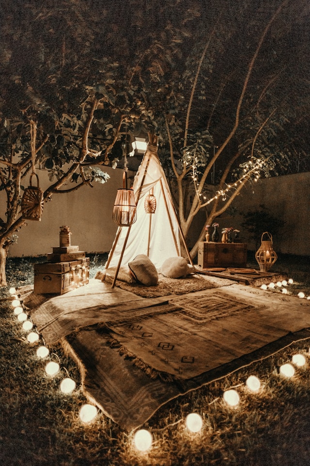 a string of lights surround a small tent with a blanket
